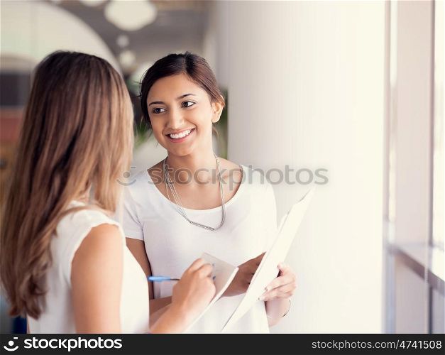 Two female collegues standing next to each other in an office