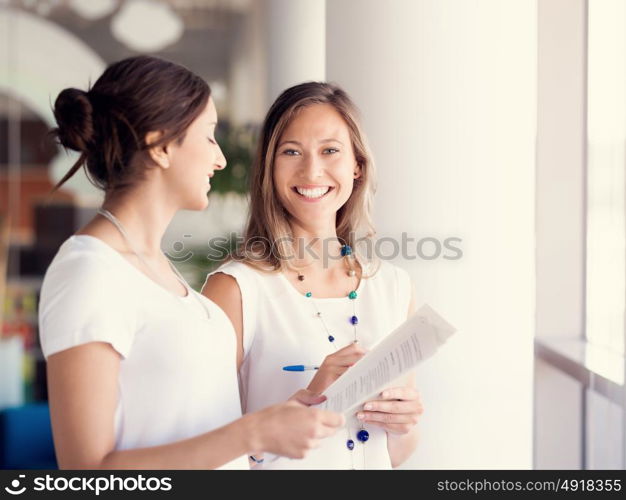 Two female collegues standing next to each other in an office