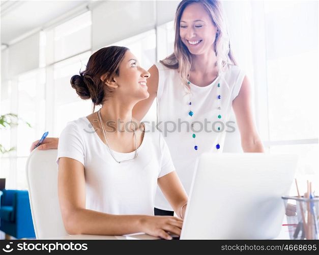Two female collegues working together in an office