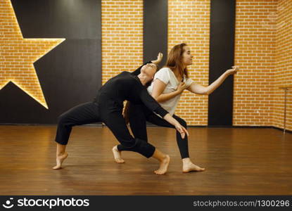 Two female contemporary dance performers poses in studio. Dancers training in class, modern elegance dancing, stretching exercise
