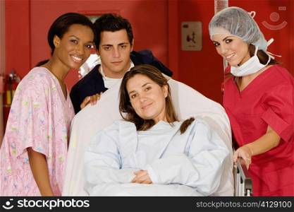 Two female doctors and a male doctor pushing a female patient on a hospital gurney