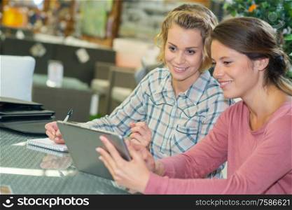 two female freelancers are sitting with electronic devices