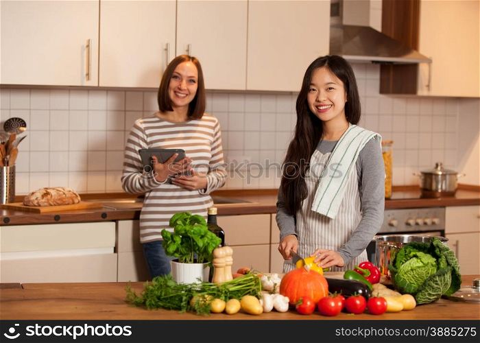 Two female friends are cooking together at home