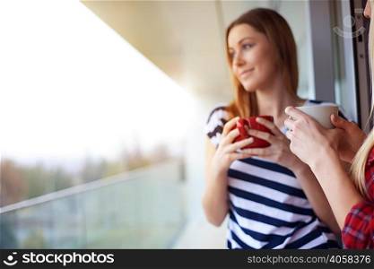 Two female friends, drinking coffee, outdoors
