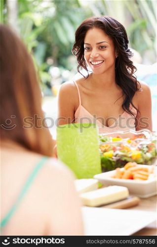 Two Female Friends Enjoying Meal Outdoors At Home
