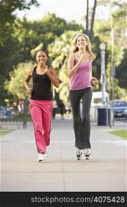 Two Female Friends Jogging On Street