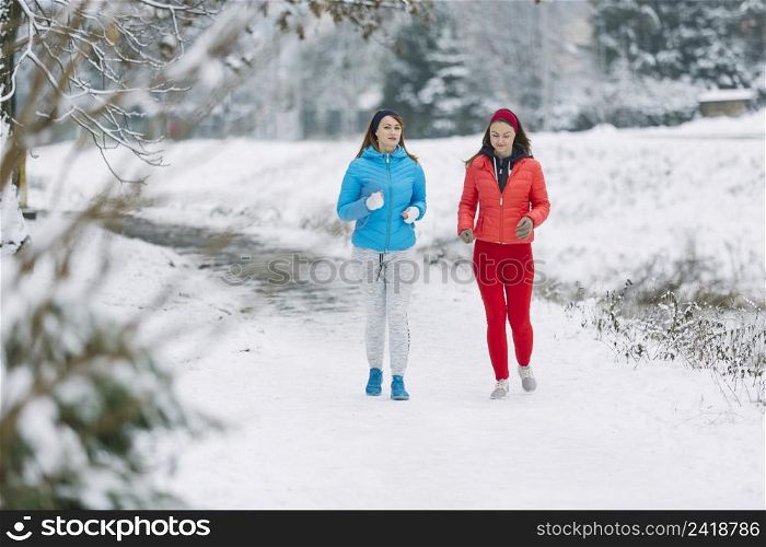two female friends jogging winter