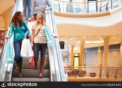 Two Female Friends On Escalator In Shopping Mall