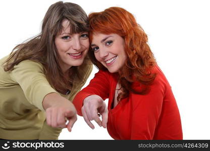 Two female friends pointing at the camera