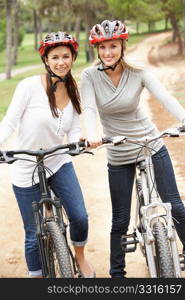 Two Female friends riding bikes in park