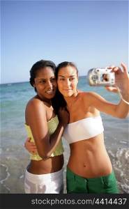 Two female friends taking self-portrait at the beach