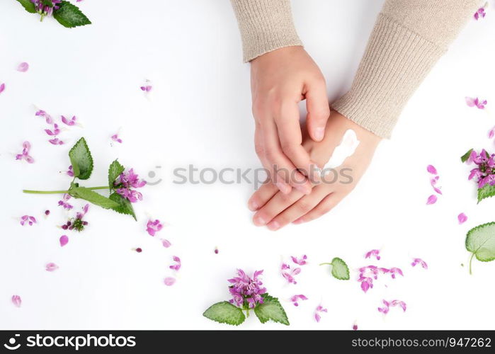 two female hands and a thick cream, top view, concept of anti-aging procedures for rejuvenating and moisturizing the skin of hands