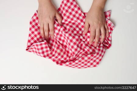two female hands holding a red kitchen napkin on a white table, top view