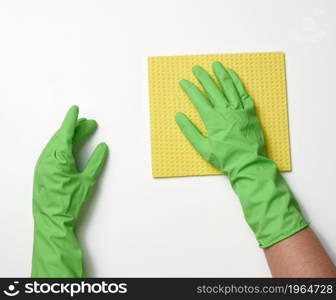 two female hands in rubber protective gloves for cleaning hold a yellow spond on a white background