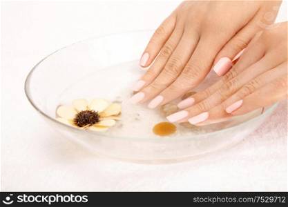 Two female hands take a bath with minerals, isolated on a white background