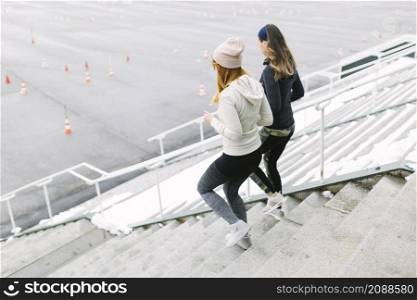 two female jogging staircase winter