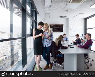 two female managers using cell telephone in office interior