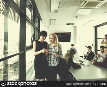 two female managers using cell telephone in office interior