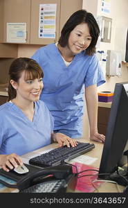 Two female nurses working on computer in doctor&acute;s office