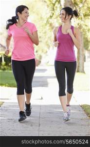 Two Female Runners Exercising On Suburban Street