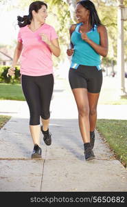 Two Female Runners Exercising On Suburban Street