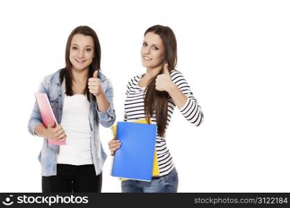 two female students showing thumbs up. two female students with exercising books showing thumbs up on white background