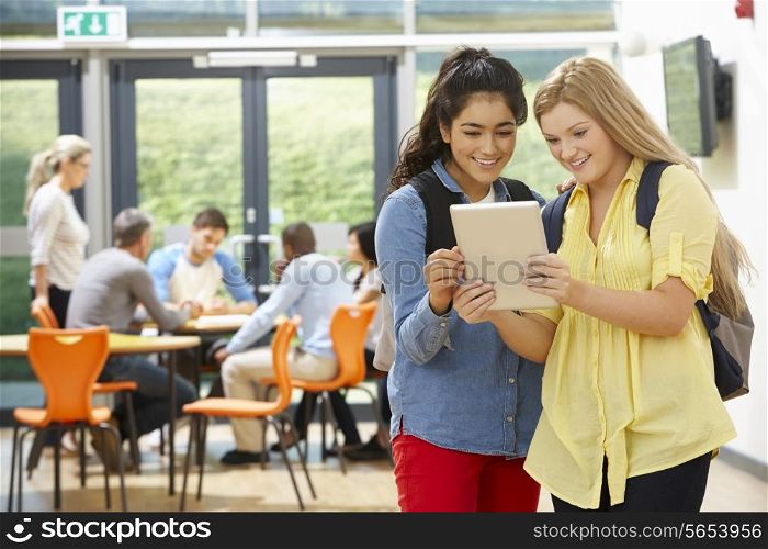 Two Female Teenage Students In Classroom With Digital Tablet