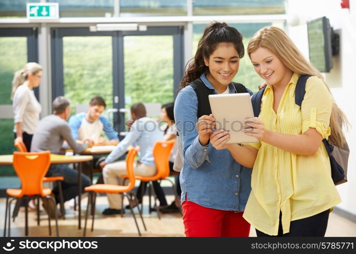 Two Female Teenage Students In Classroom With Digital Tablet