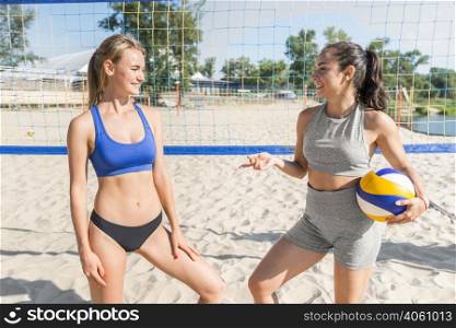 two female volleyball players beach with net