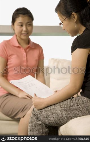 Two female workers discussing a document