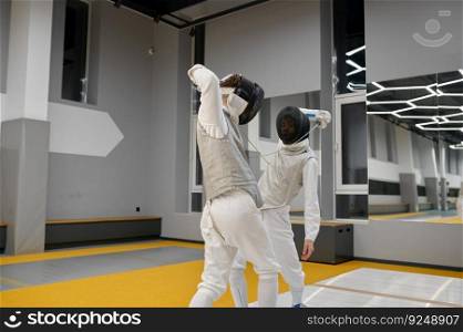 Two fencers exercising movements in duel at fencing room of professional martial art school. Two fencers exercising movements in duel at fencing room
