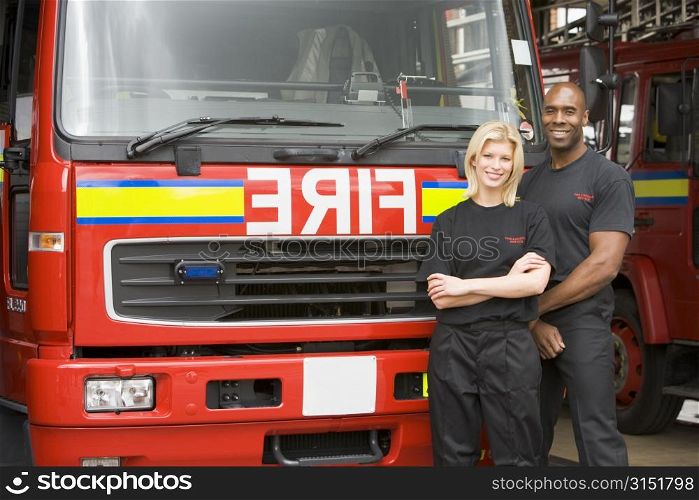 Two firefighters standing in front of fire engine