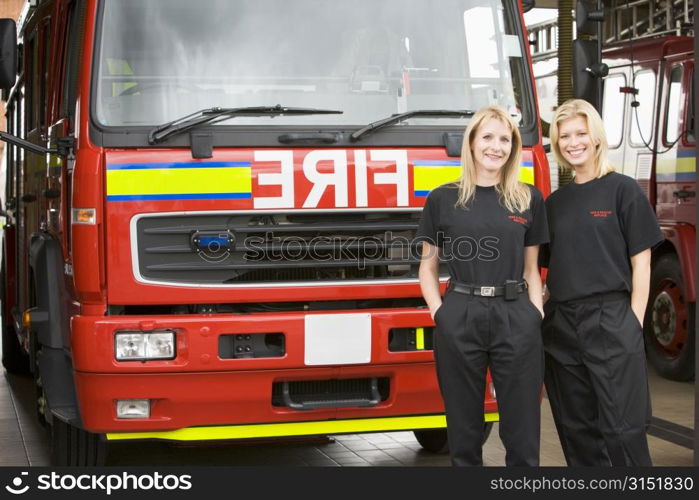 Two firefighters standing in front of fire engine