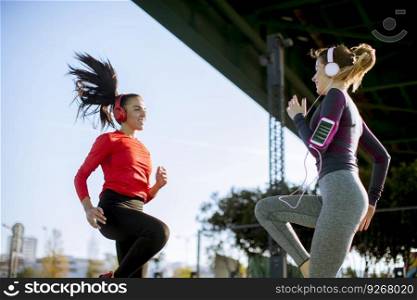 Two fitness women doing  exercise before running outdoor in urban environment