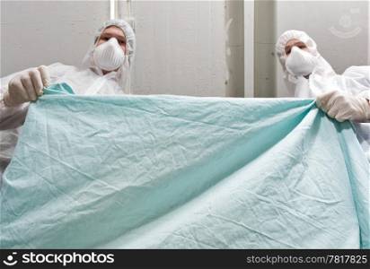 Two forensic investigators covering a dead victim with a sheet, seen from the dead persons perspective