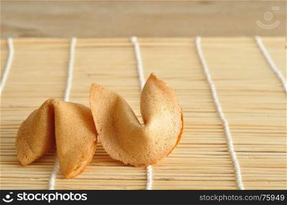 Two fortune cookies isolated on a bamboo background