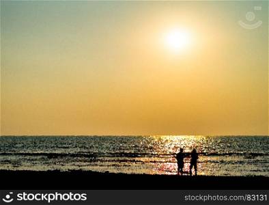 Two freinds silhouette meeting ocean sunset landscape backdrop