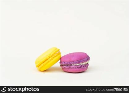Two fresh macaroon confection over beige background. Fresh macaroon confection