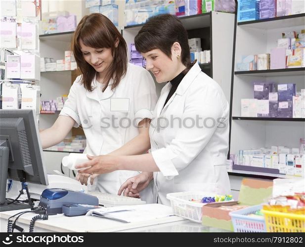 Two Friendly Pharmacists Working Together in the Drugstore .