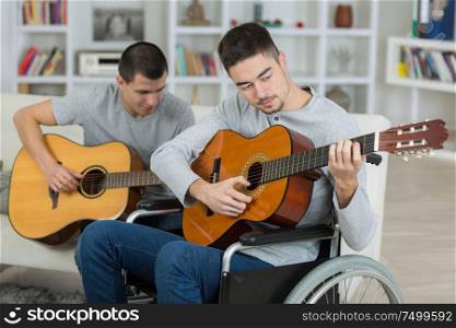 two friends are playing the guitar