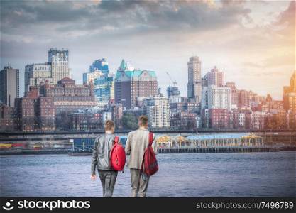 Two friends by the river against the backdrop of New York