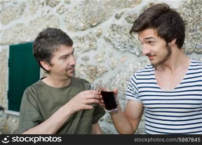 two friends having a drink and talking outdoors
