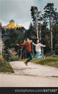 Two friends jumping in front of Pena Palace in Sintra, Portugal