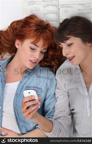 Two friends looking at a cellphone.