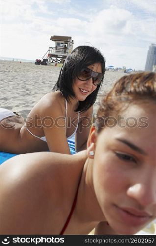 Two friends sunbathing on beach