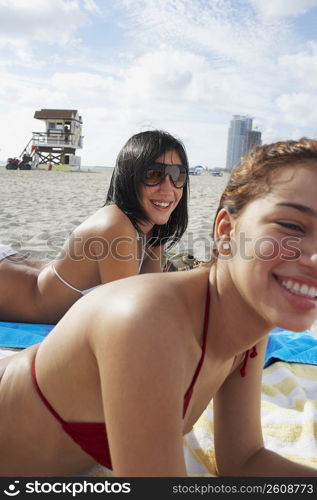 Two friends sunbathing on beach