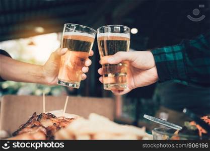 Two friends toasting and clinking with glass of beer.