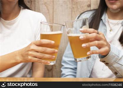 Two friends toasting with beers