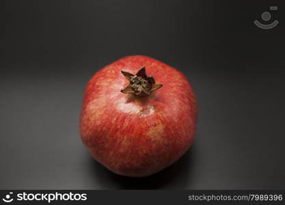 Two fruit juicy Spanish pomegranate on a dark background.. Two fruit juicy Spanish pomegranate on a dark background