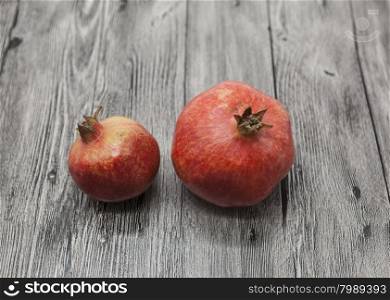 Two fruit juicy Spanish pomegranate on the wooden background. Two fruit juicy Spanish pomegranate on the wooden background.
